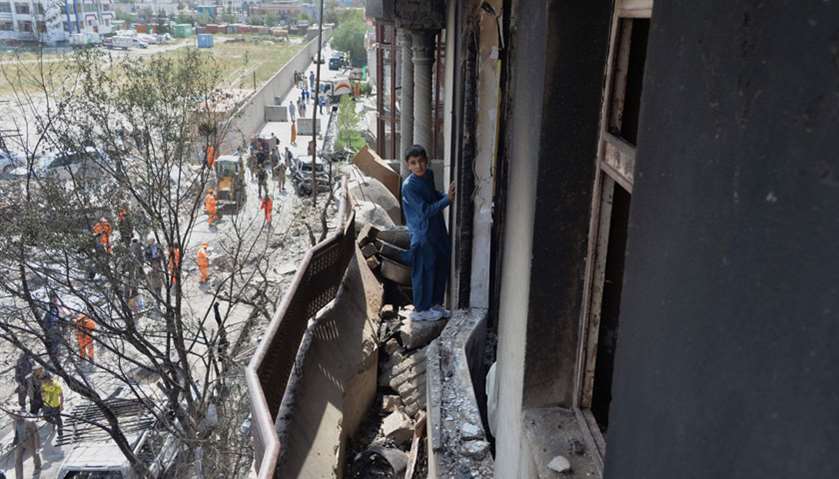 An Afghan boy looks on next to damaged homes near the site of an attack in Kabul