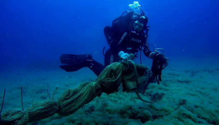 A Coast Guard diver collects abandoned fishing nets from sea bottom off the coast of Lazio
