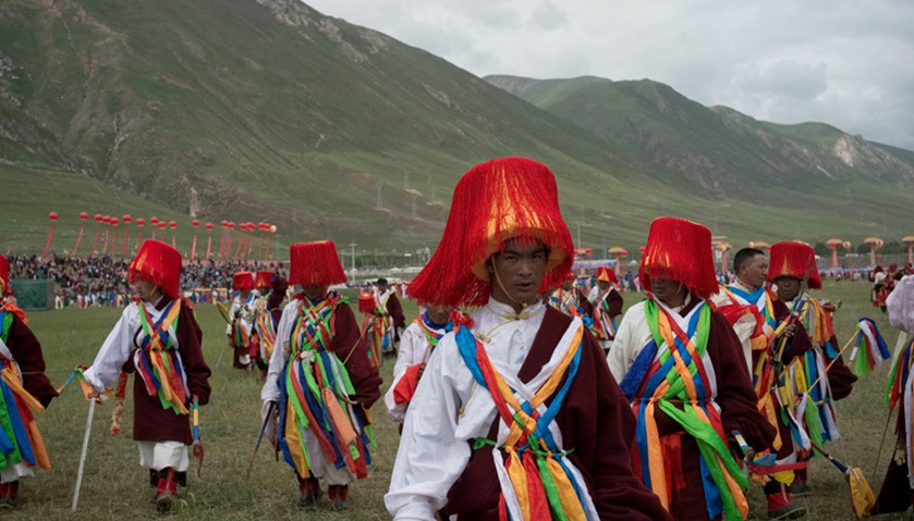 Ethnic Tibetans in traditional dress walk across the grounds