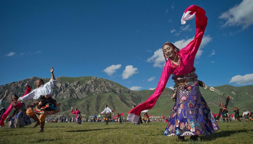 Ethnic Tibetans wearing traditional costumes dance at a local government sponsored festival in Yushu