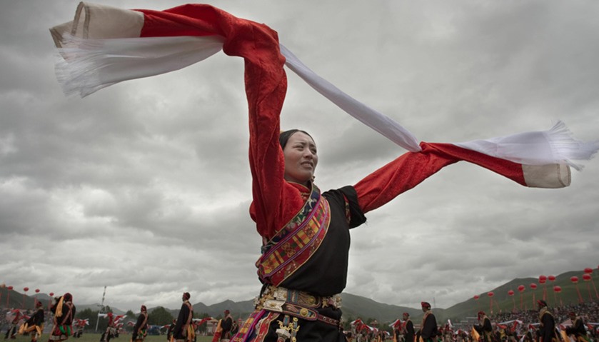 An ethnic Tibetan woman wearing a traditional costume dances