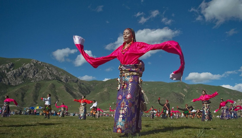 Ethnic Tibetans wearing traditional costumes dance at a local government sponsored festival in Yushu
