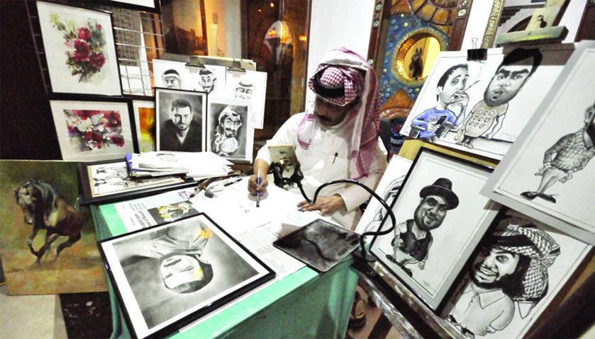 Mohamed Rageh works on a charcoal portrait.