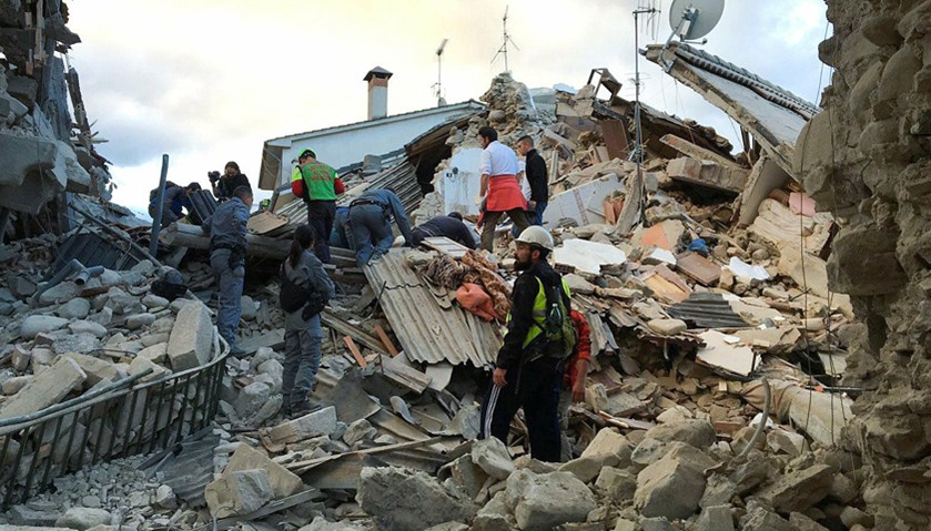 Rescuers work at a collapsed house following a quake in Amatrice, central Italy