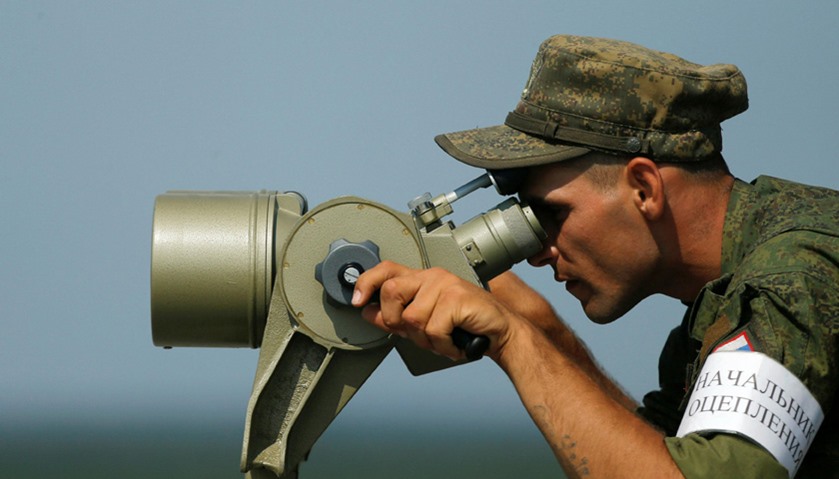 A Russian servicemen uses binoculars during a competition of the International Army Games 2016