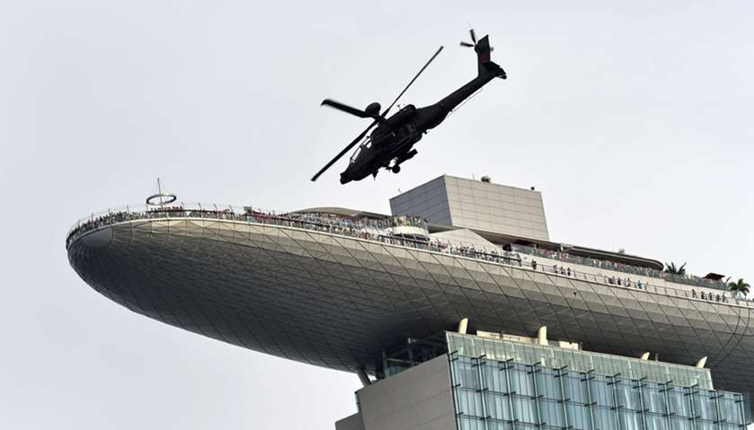 An Republic of Singapore Air Force Apache helicopter flies past the Marina Bay Sands