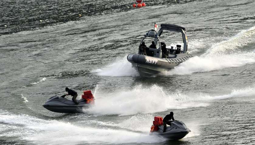Singaporean navy personnel demonstrate a high speed water chase during the 52nd National Day celebra