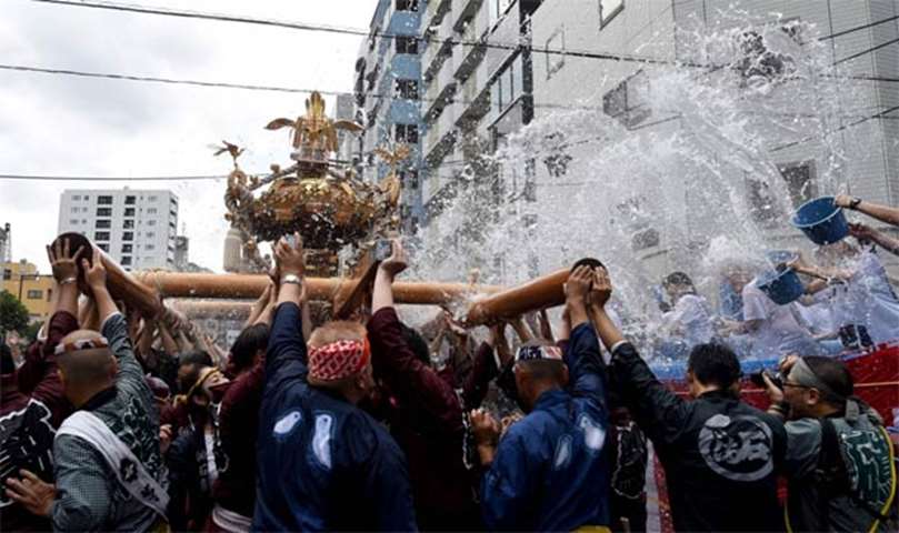 Water is splashed as residents carry a portable shrine in Tokyo on Sunday