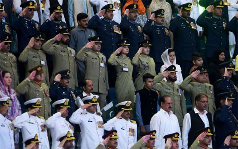 Pakistani armed forces officials salute during the national anthem