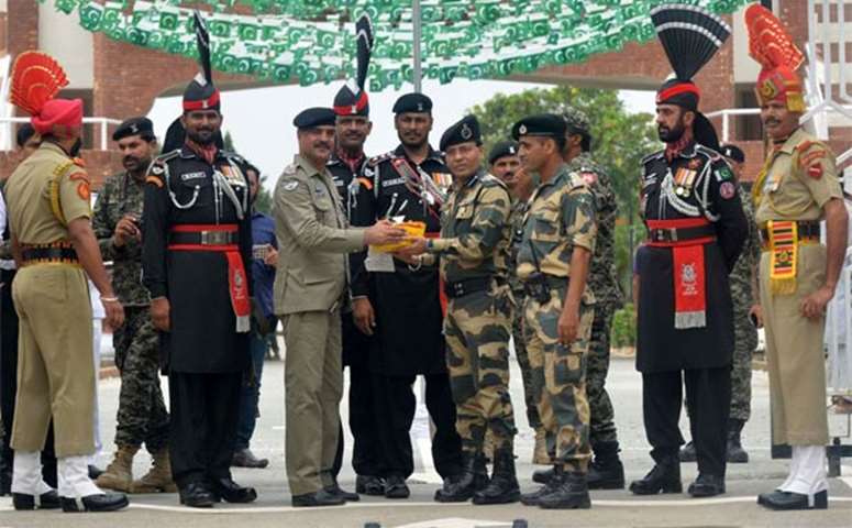 Pakistani Wing Commander Bilal presents sweets to Indian Border Security Force Commandant Sudeep