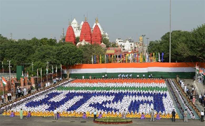 Indian schoolchildren sit in formation forming Hindi script that reads \'Bharat\' (India)