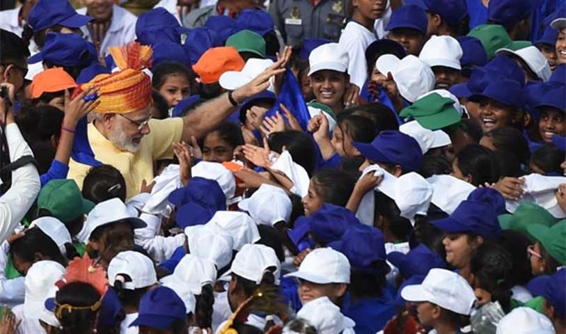 Prime Minister Narendra Modi is surrounded by schoolchildren participating in the celebrations