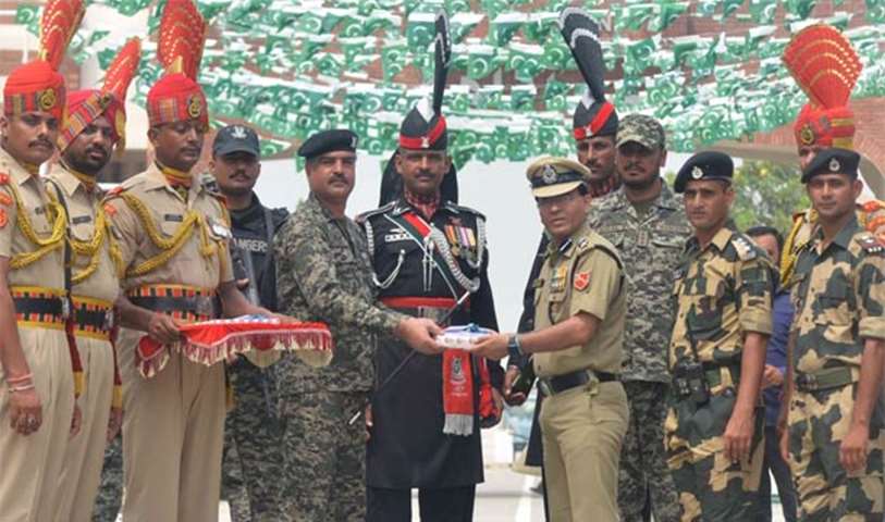Border Security Force Commandant Sudeep presents sweets to Pakistani Wing Commander Bilal at Wagah
