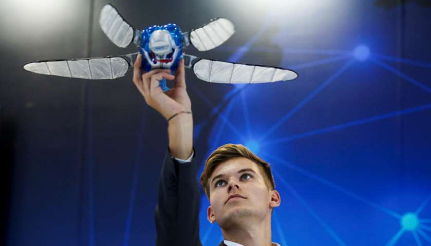 A man launches a flying object developed by Festo at the 2017 World Robot Conference in Beijing