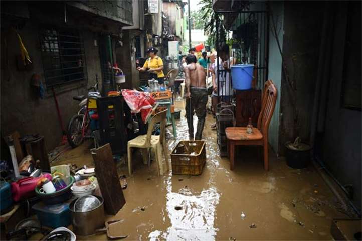 Residents clean their mud-filled homes after flooding submerged their homes in Marikina City