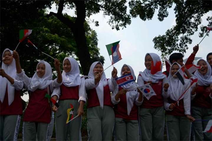 Indonesian students wave flags as they watch the torch relay in Jakarta