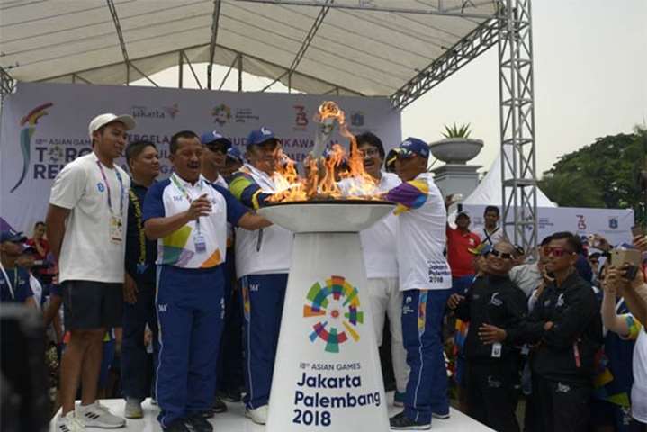 Officials light the 2018 Asian Games torch during the torch relay in Jakarta on Thursday