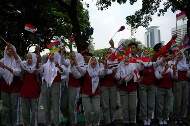 Students wave flags in Jakarta. The Asian Games will be held from August 18 to September 2