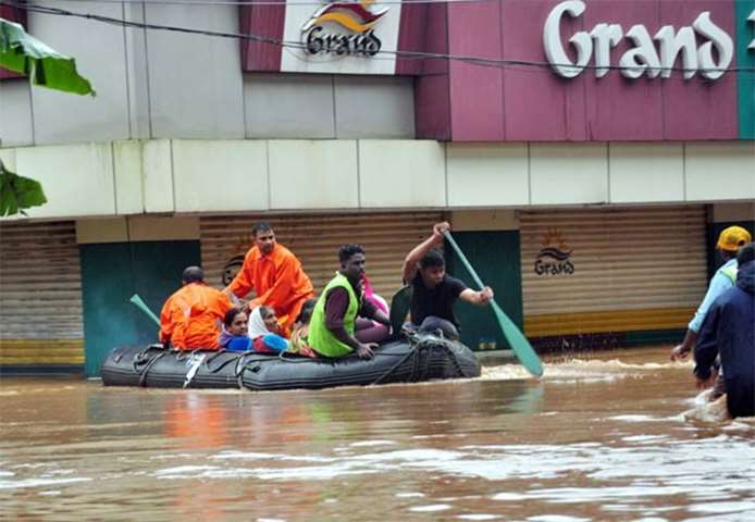 Rescue personnel evacuate local residents in a boat in Aluva on Thursday