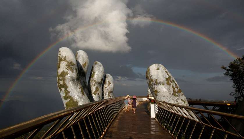 A double rainbow appears above giant hands structure on the Gold Bridge on Ba Na hill near Danang ci