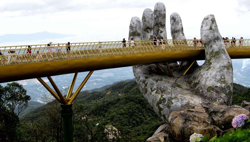 Visitors walk along the 150-meter long Cau Vang \"Golden Bridge\" in the Ba Na Hills near Danang