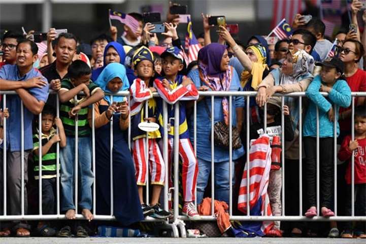 People watch the National Day parade in Putrajaya, on the outskirts of Kuala Lumpur