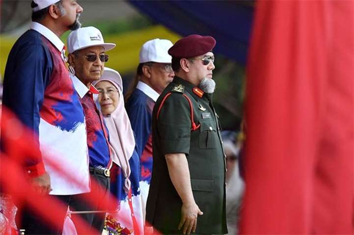 Malaysia\'s King Sultan Muhammad V and Prime Minister Mahathir Mohamad watch the parade