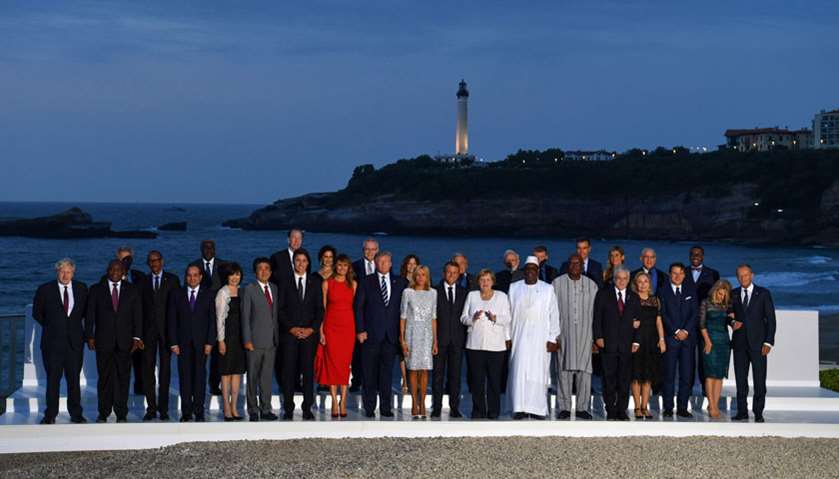 G7 leaders and guests pose for a family picture with the Biarritz lighthouse in the background