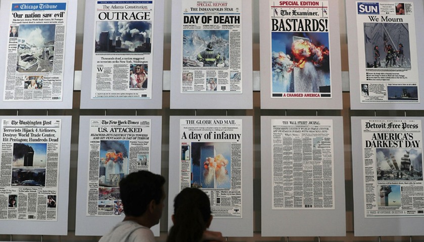 Visitors browse newspaper front pages with the story of the 9/11 terror attacks