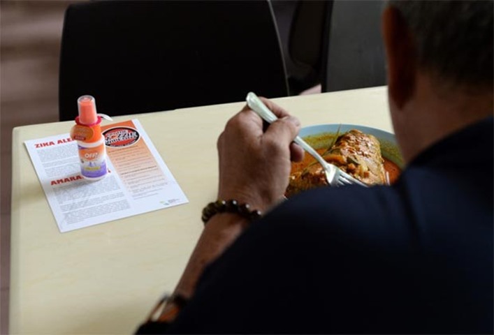 A Zika outbreak alert pamphlet and insect repellant is seen after being distributed to patrons