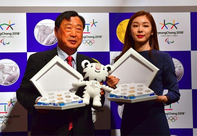 Lee Hee-Beom, of the organising committee, and former figure skating champ Kim Yu-Na pose with coins