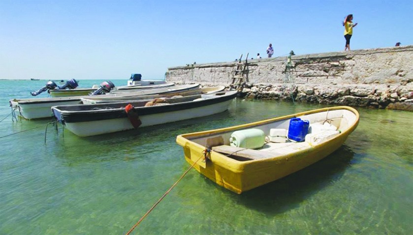 Small boats are moored at a small port in Al Shamal