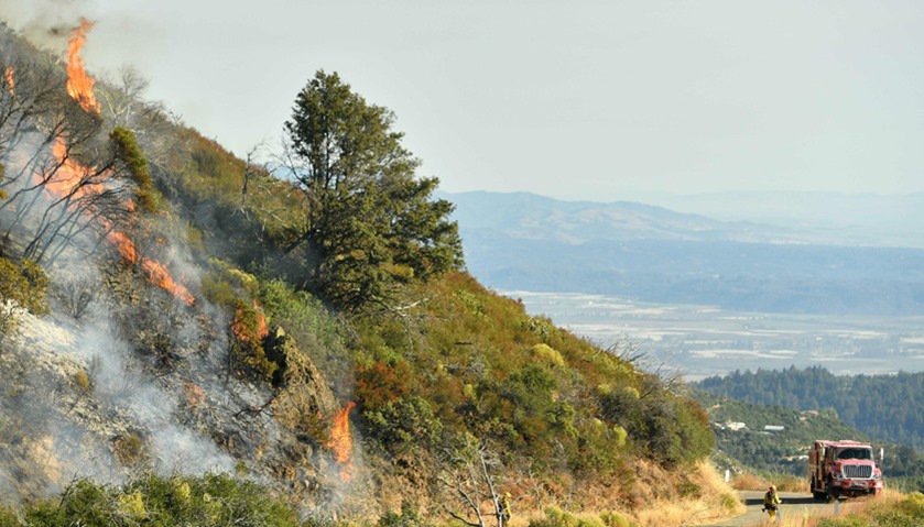 A spot fire flares up along a road in the Santa Cruz Mountains near Morgan Hill