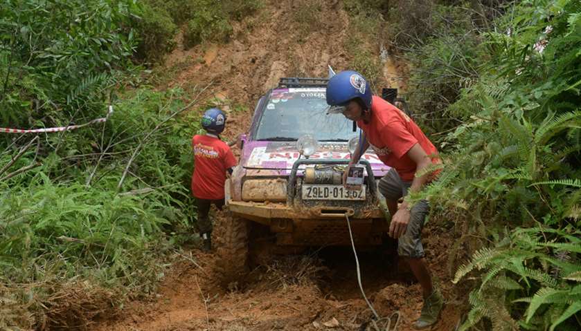 Competitors using a winch to get their vehicle out of the mud while taking part in the Vietnam Offro