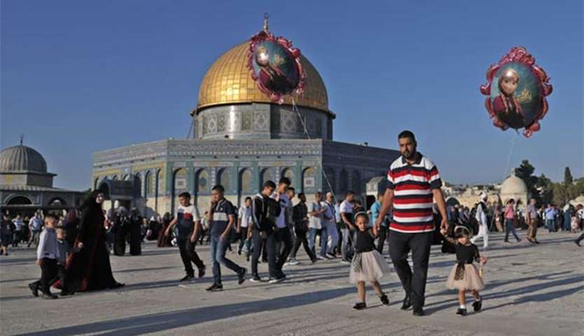 Palestinians walk near the Dome of Rock following the Eid al-Adha prayers in Jerusalem on Friday
