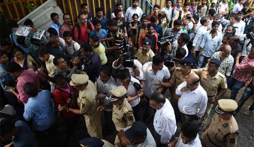 Security personnel gather at the scene of a stampede in Mumbai on Friday