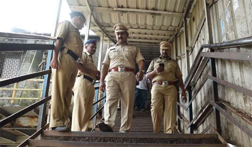 Security personnel examine the scene of a stampede on a Mumbai railway bridge