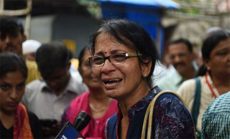 A relative of a victim of a stampede on a railway bridge reacts outside a mortuary in Mumbai