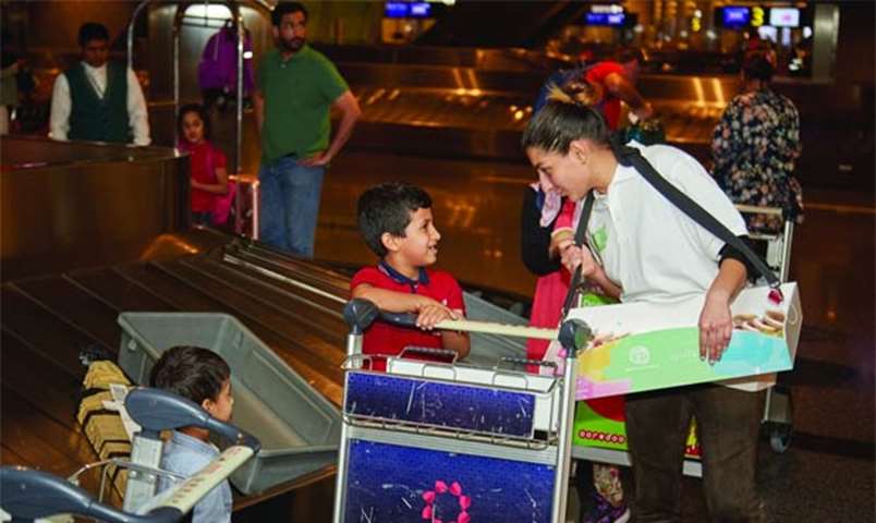A welcome team member interacts with children upon their arrival at HIA