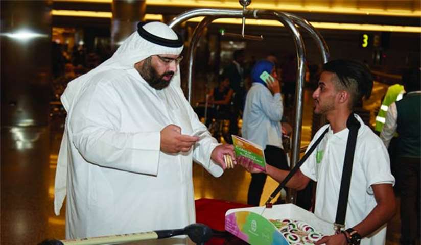 A visitor receiving welcome treats from Qatar Tourism Authority at Hamad International Airport