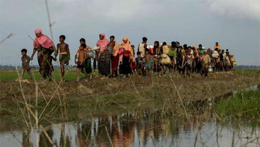 Rohingya refugees from Rakhine state carry their belongings as they flee violence, near Ukhia