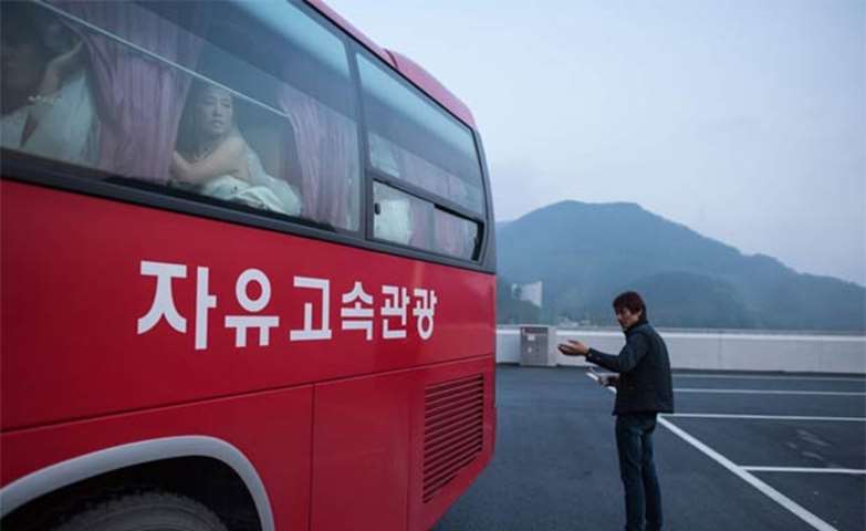 A bride looks from the window of a bus as it arrives at a mass wedding ceremony in Gapyeong