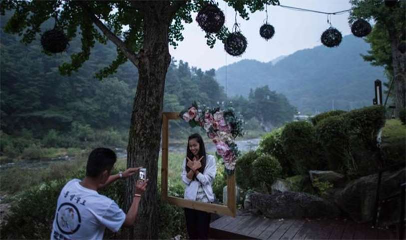 A bride poses for a photo at a hotel the night before taking part in a mass wedding ceremony
