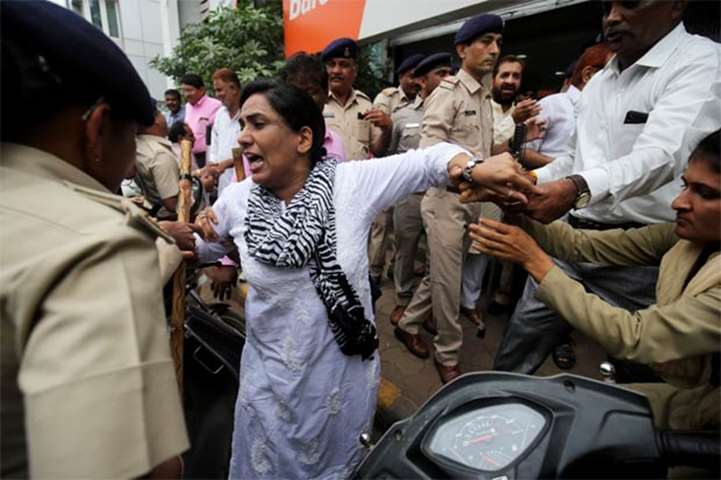 Police detain a Congress party supporter during a strike against hike in fuel prices in Ahmedabad
