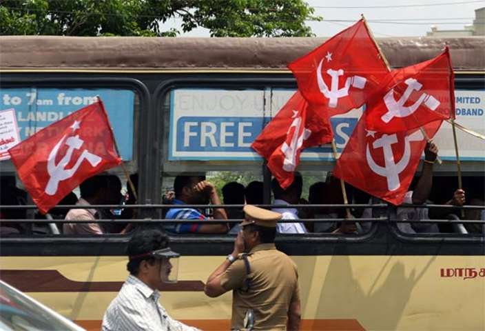 Communist Party of India - Marxist members hold flags after being detained by police in Chennai