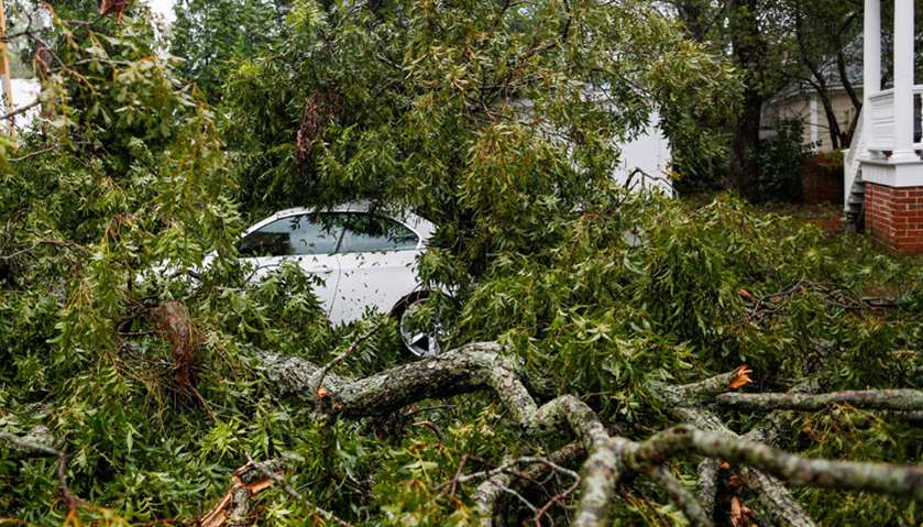 Leaves, branches and other debris surround and cover a car during the passing of Hurricane Florence