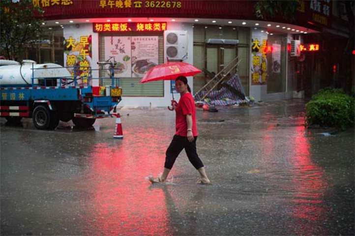 A woman walks through flooded streets in Yangjiang, Guangdong province