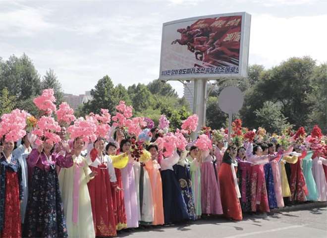 North Korean people greet Moon Jae-in and Kim Jong Un during a car parade in Pyongyang