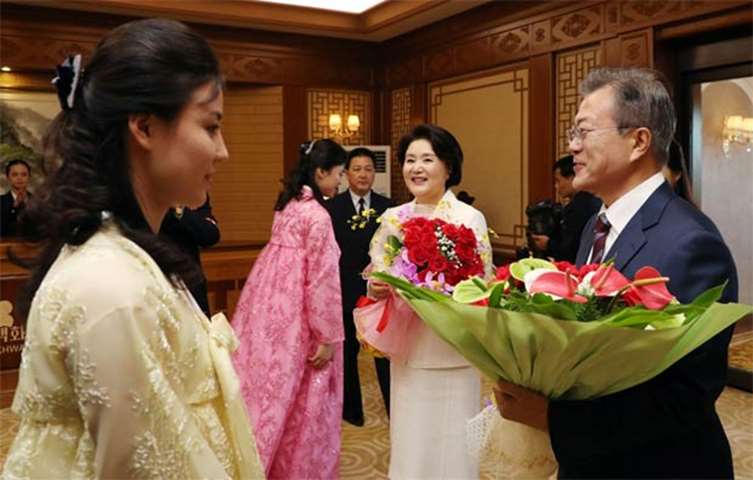 Moon Jae-in and his wife Kim Jung-sook receive flowers as they arrive at Baekhwawon State Guesthouse