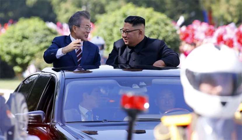 Kim Jong Un talks with Moon Jae-in in an open-topped vehicle as they drive through Pyongyang